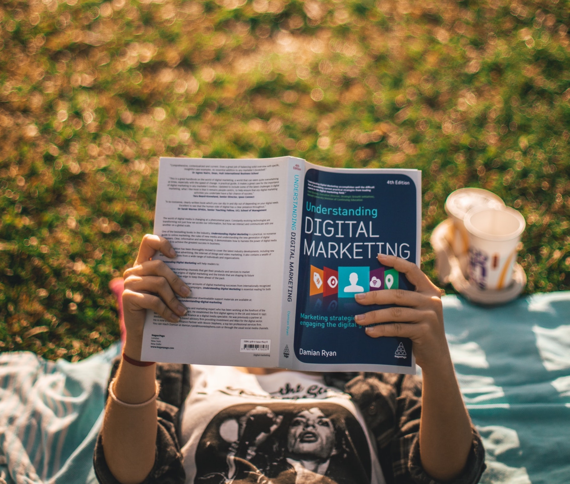 Woman reading a book titled “Digital Marketing.”
