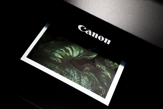 A Canon printer with a colored printout