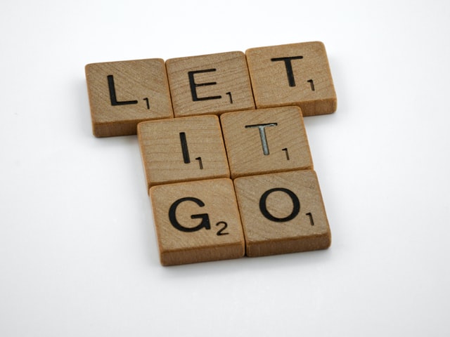 “Let it go” spelled with scrabble wooden tiles.