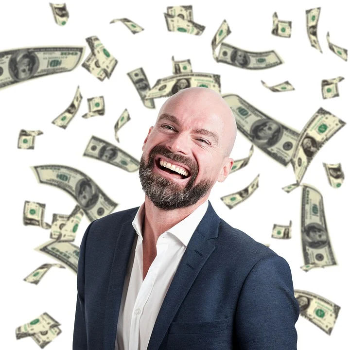 An image of a smiling businessman surrounded by a flurry of dollar bills.