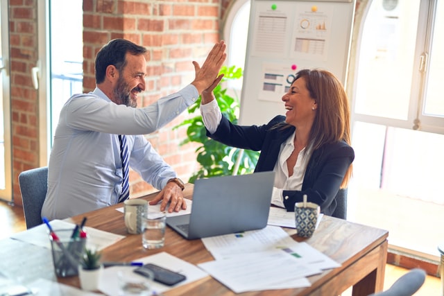 Man and woman giving high five at office