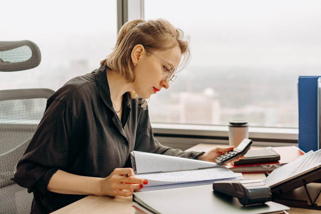 A woman in a black dress shirt using a calculator