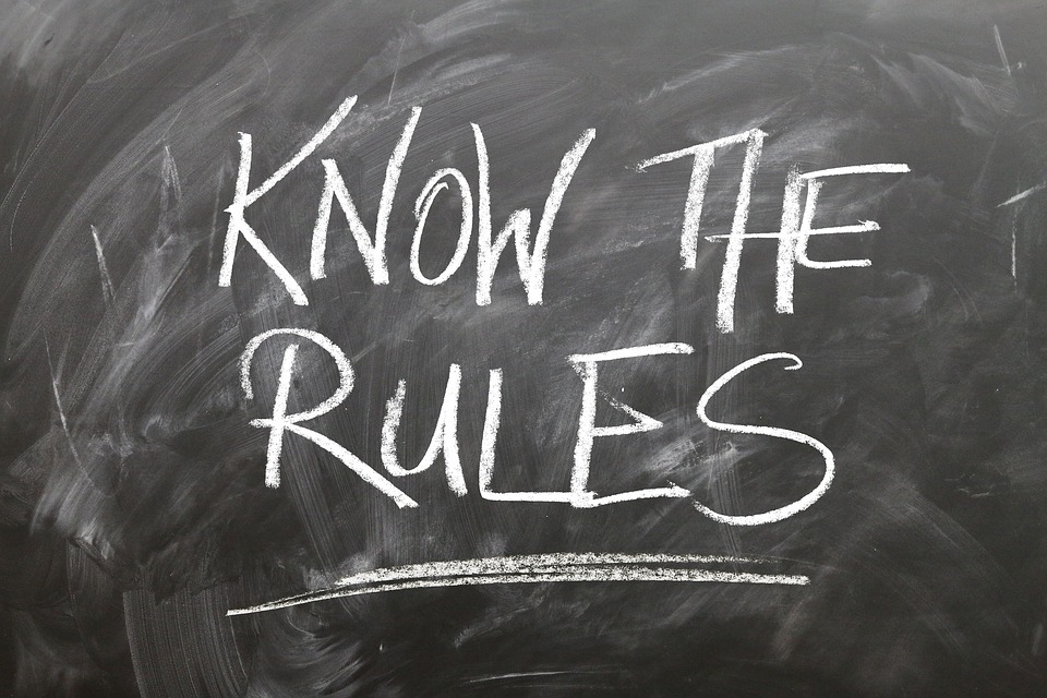 A blackboard with “Know the Rules” written on it in chalk.