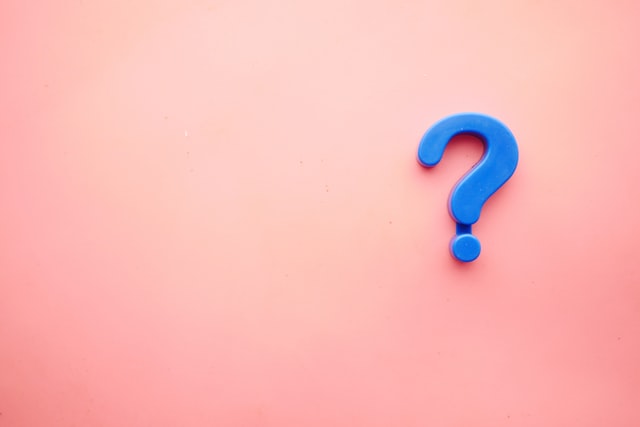 Blue question mark displayed on a pink background.