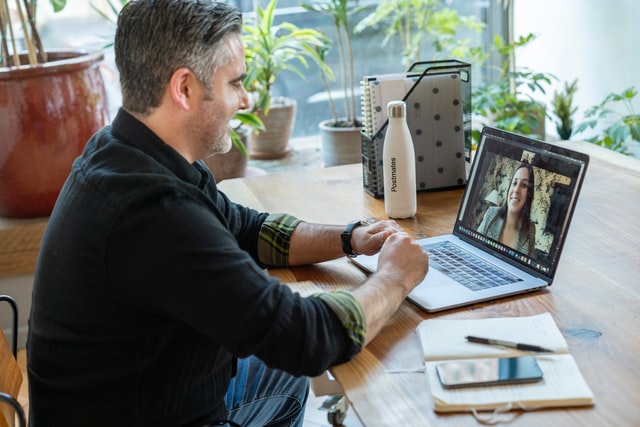 A man having a virtual business meeting with a female colleague.