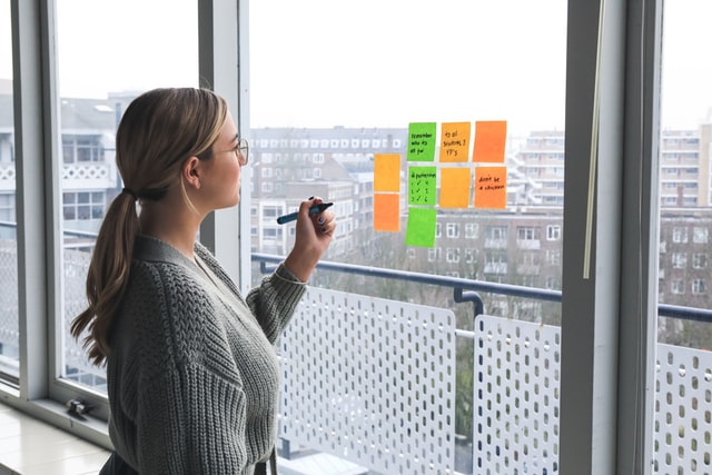 Woman writing on Post-it notes