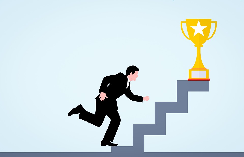 A man in a business suit climbs steps toward a trophy.