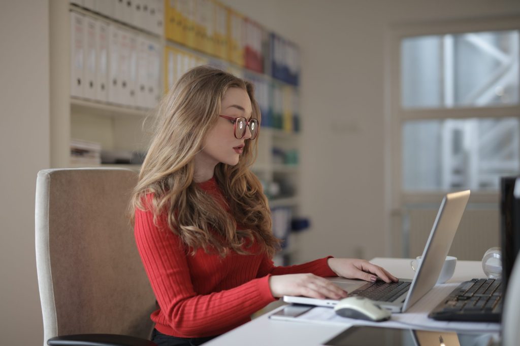 A woman focusing intently while working on a laptop.