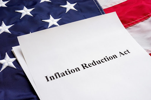 Papers with Inflation Reduction Act and the U.S. flag.