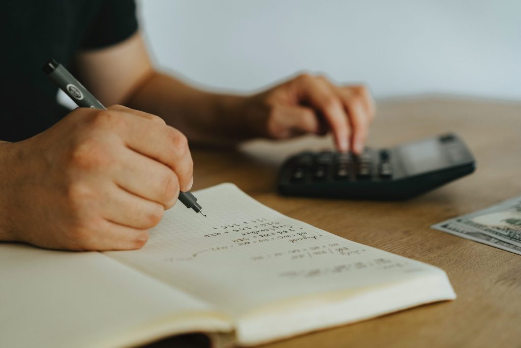 Person writing on a white notebook.
