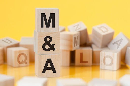 A pile of scrabble blocks, spelling out M&A.