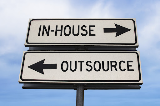 Outsource versus in-house road sign.